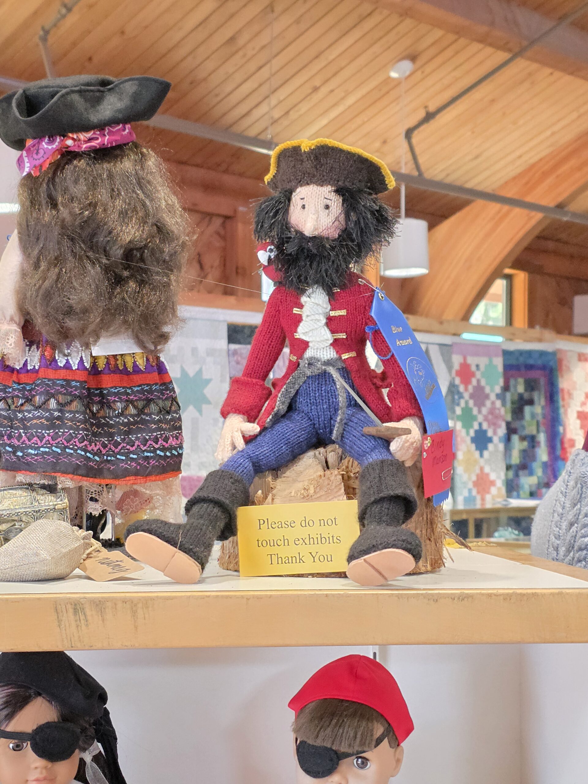 Handmade pirate doll with a blue award ribbon in the Pierce County Fair craft exhibit.