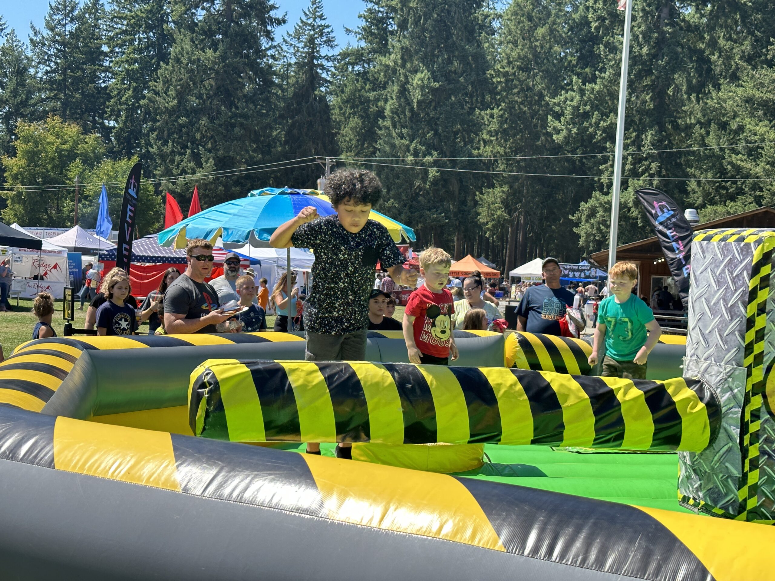 A child jumps over a padded beam in an inflatable amusement game at the Fair.