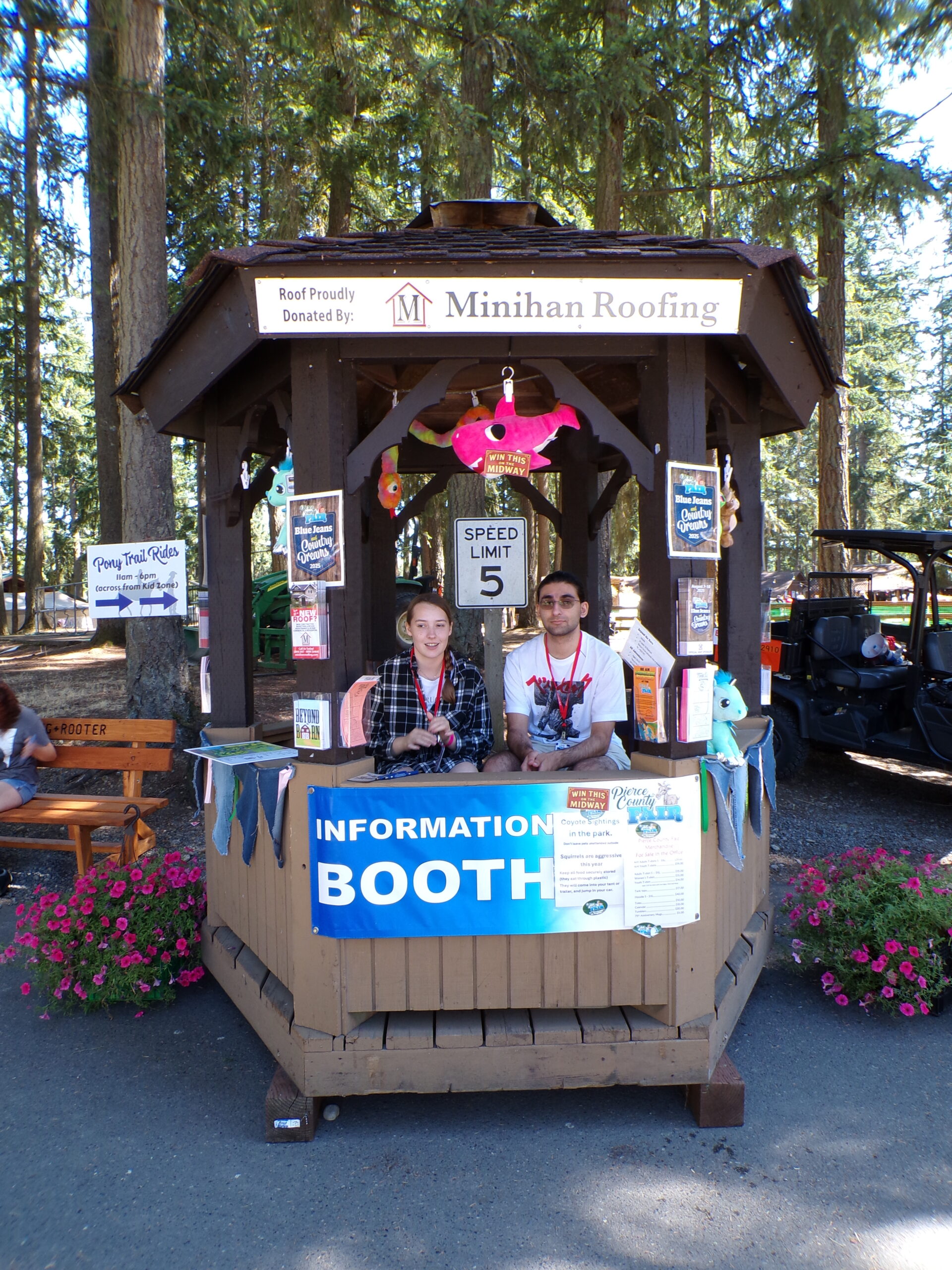 Two volunteers welcoming visitors at the Pierce County Fair information booth.