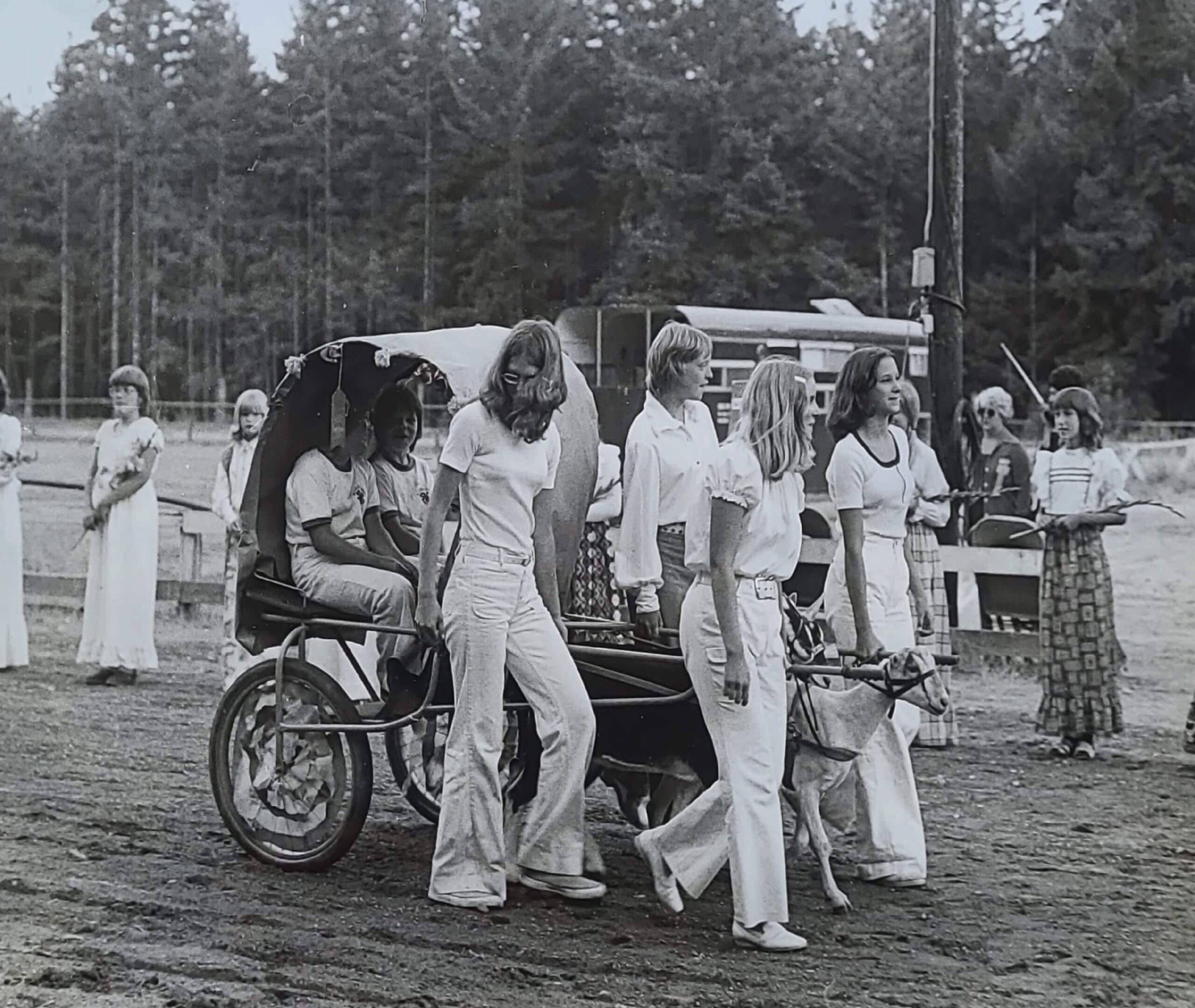 Historical photograph of young fair participants leading a goat pulling a small covered cart.