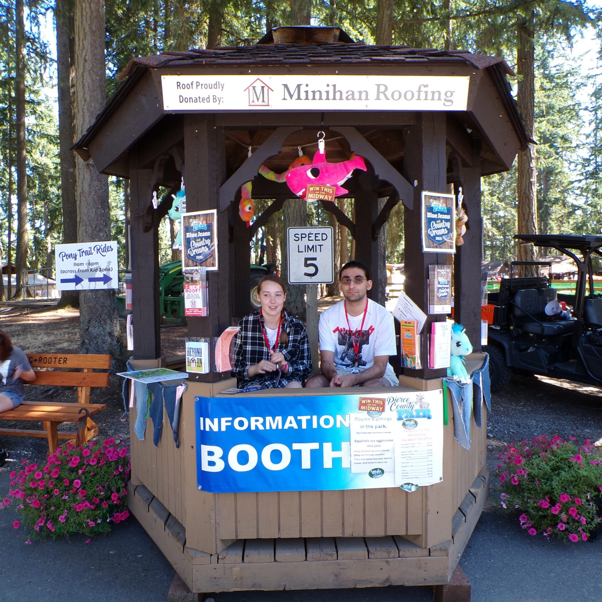 Two volunteers welcome visitors from the Fair information booth.